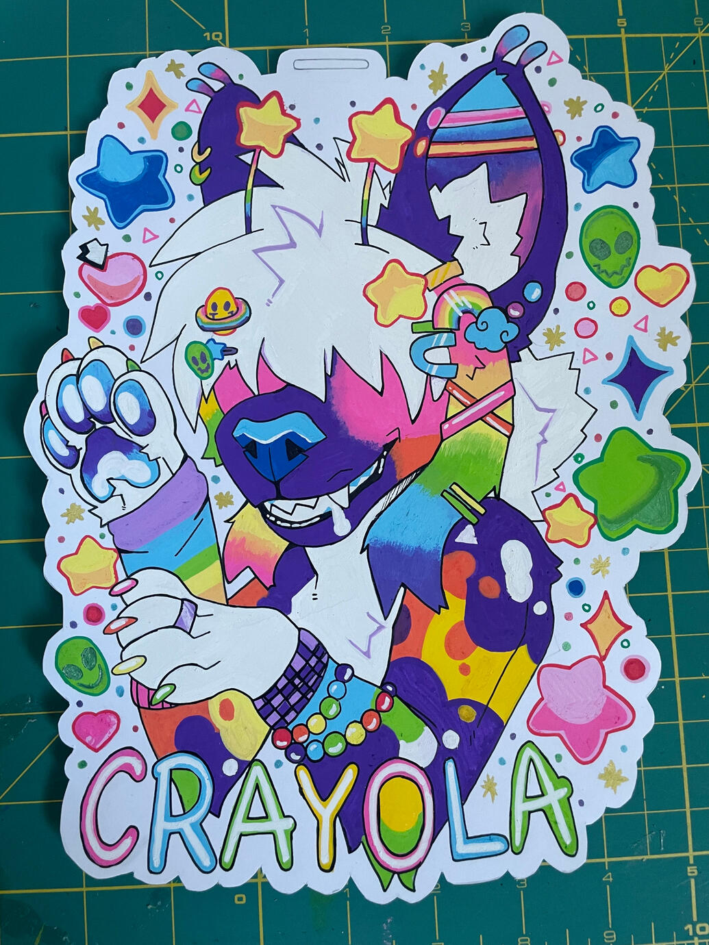 a posca badge measuring at 10in for an African wild dog/alien hybrid named Crayola.